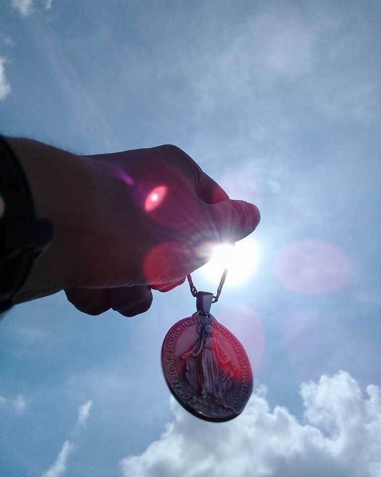 María soplo y fuego del Espíritu Santo.Medalla de la Virgen en puesta del sol